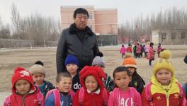 这家公司支教老师为幼儿园小朋友送书包